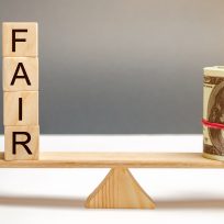 Dollars and the inscription Fair on wooden blocks. Balance. Fair value pricing, money debt. Fair deal. Reasonable price. Justified risk. Honest loan. Secured loans.