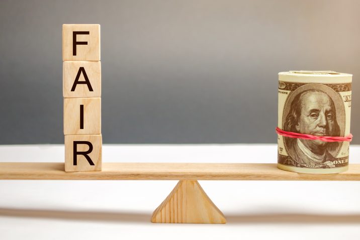 Dollars and the inscription Fair on wooden blocks. Balance. Fair value pricing, money debt. Fair deal. Reasonable price. Justified risk. Honest loan. Secured loans.