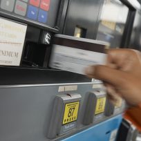 Person paying with credit card at gas pump, motion blur