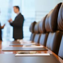 Side view of two blurred businessmen talking in conference room