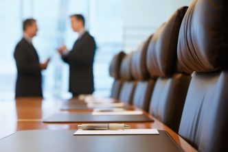 Side view of two blurred businessmen talking in conference room