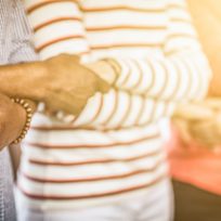 Creative team meeting hands together in line. Young people in casual clothes are holding hands. Unity and teamwork concept.