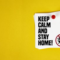 Keep Calm And Stay Home motivation letter written on post-it paper against Coronavirus