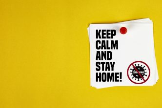 Keep Calm And Stay Home motivation letter written on post-it paper against Coronavirus