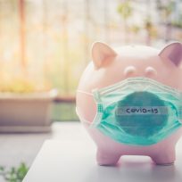 Piggy bank with Face Mask, Financial crisis and market crash due to virus spread.