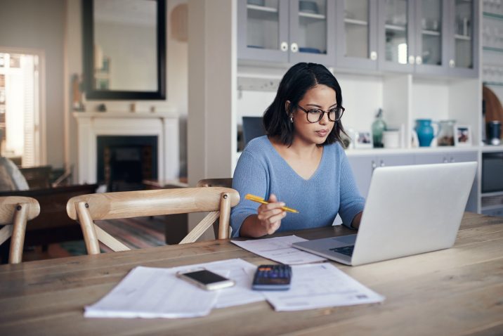 Shot of a young woman using a laptop while working from home