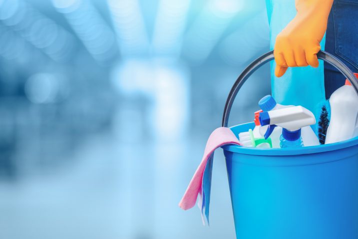 Concept of quality cleaning. The cleaning lady standing with a bucket and cleaning products.