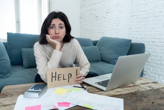 Portrait of worried young woman feeling stressed and desperate asking for help in paying bills, debts, tax expenses and accounting home finances with laptop. In online banking and financial problems.