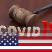 Wooden judge gavel with letters covid19 on table and usa flag. Concept of quarantine and law against covid-19.