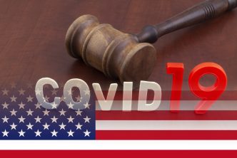 Wooden judge gavel with letters covid19 on table and usa flag. Concept of quarantine and law against covid-19.