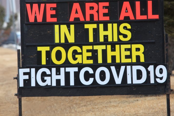 A sign or billboard in front of a business that states we are all in this together fight Covid-19.