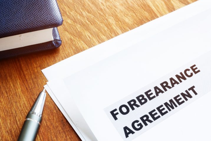 Forbearance agreement papers with pen and notepad.