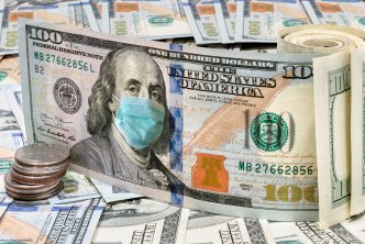 100 dollar money bills with medical face mask, COVID-19 coronavirus in USA.