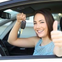 Happy car owner with a key and thumbs up